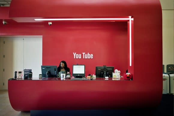 A bright red office lobby with the YouTube logo in white on the wall.