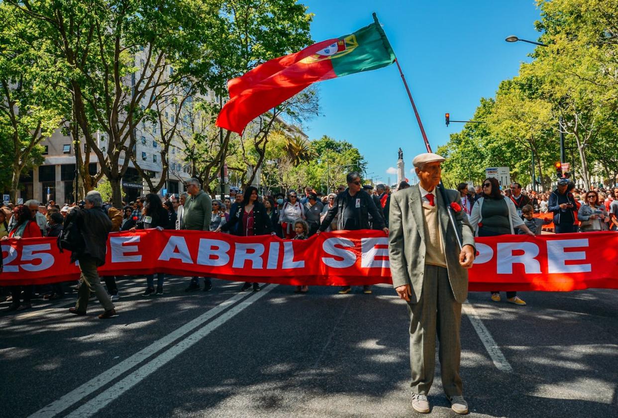 Crowds of Portuguese people hold carnation flowers on Avenida da Liberdade in Lisbon to celebrate the military coup that overthrew the authoritarian regime in 1974. <a href="https://www.shutterstock.com/es/image-photo/lisbon-portugal-april-25-2022-crowds-2149547065" rel="nofollow noopener" target="_blank" data-ylk="slk:Alexandre Rotenberg / Shutterstock;elm:context_link;itc:0;sec:content-canvas" class="link ">Alexandre Rotenberg / Shutterstock</a>