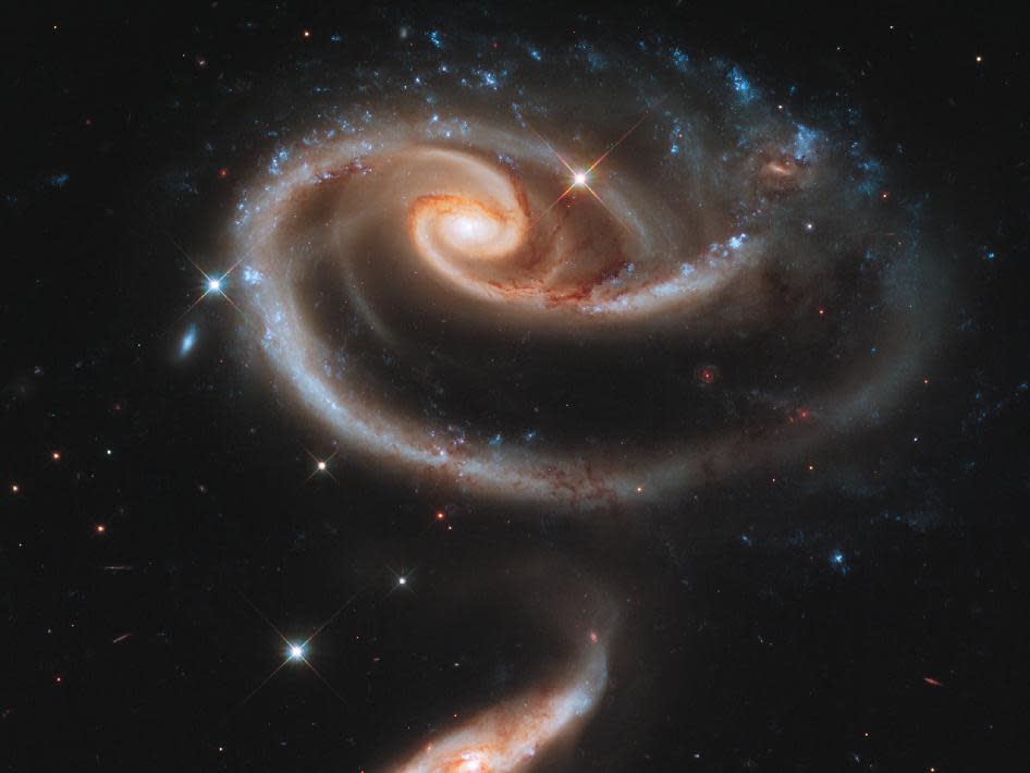 <p> <strong>Taken by:</strong> Hubble Space Telescope </p> <p> A whirlpool-like spiral galaxy is being distorted by the gravitational pull of a neighbor in this image from NASA&apos;s Hubble Space Telescope. The photo was released for the observatory&apos;s 21st birthday in 2011. The picture shows a pair of interacting galaxies called Arp 273. The large spiral galaxy at the top is known as UGC 1810. It is being pulled apart by the tidal gravitational forces (similar to the tug of the moon on Earth) from its companion, the smaller galaxy UGC 1813. </p>