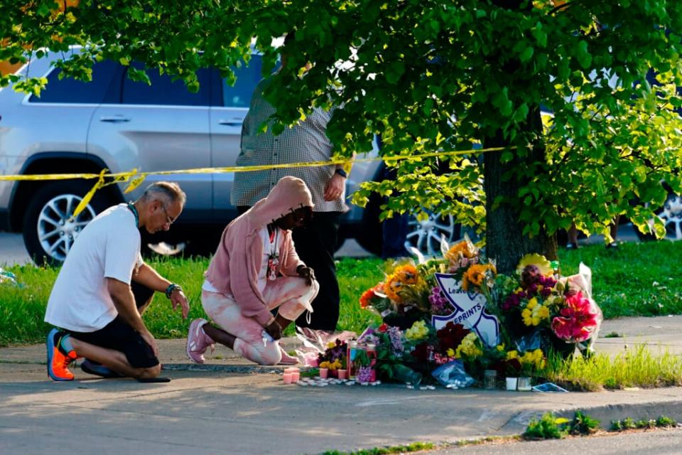 People pay their respects outside the scene of a shooting at a supermarket in Buffalo, N.Y., Sunday, May 15, 2022. (AP Photo/Matt Rourke)