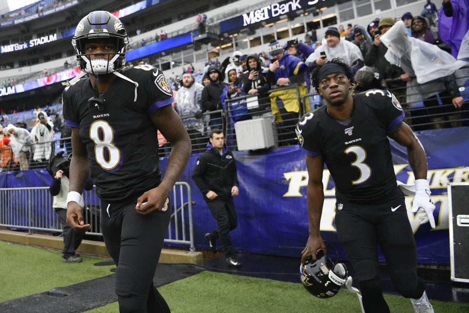 Baltimore Ravens quarterbacks Lamar Jackson, left, and Robert Griffin III, right, take the field to begin warming up before the start of an NFL football game against the San Francisco 49ers, Sunday, Dec. 1, 2019, in Baltimore, Md. (AP Photo/Nick Wass)