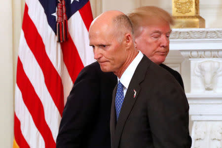 Florida Governor Rick Scott and U.S. President Donald Trump cross paths during a discussion about school shootings with state governors from around the country at the White House in Washington, U.S. February 26, 2018. REUTERS/Jonathan Ernst