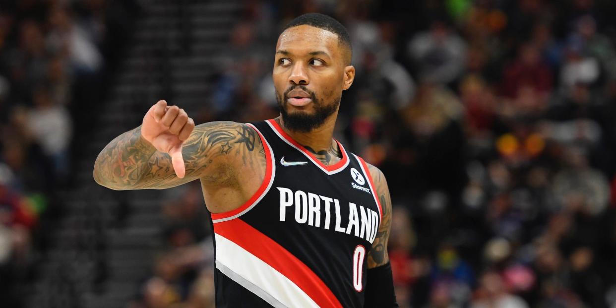 Damian Lillard gives a thumbs-down while looking off the court.