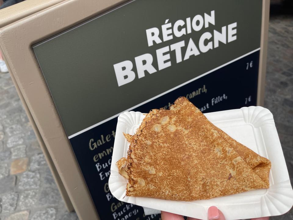 hand holding a plate of crepes at disneyland paris