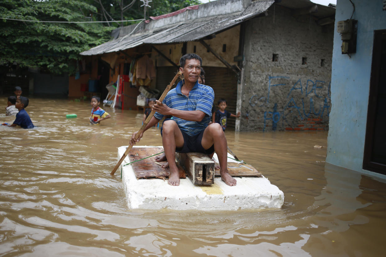 An Indonesian man sits on a raft at a flooded neighborhood in Jakarta, Indonesia, Tuesday, Feb. 21, 2017. Torrential rains in the Indonesian capital have overwhelmed drains and flooded roads and thousands of homes. Floods and deadly landslides are a fact of life for Indonesians during the wet season, with other major cities suffering repeated flooding. (AP Photo/Dita Alangkara)