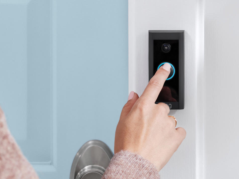 Person pressing doorbell button on Ring Video Doorbell Wired.