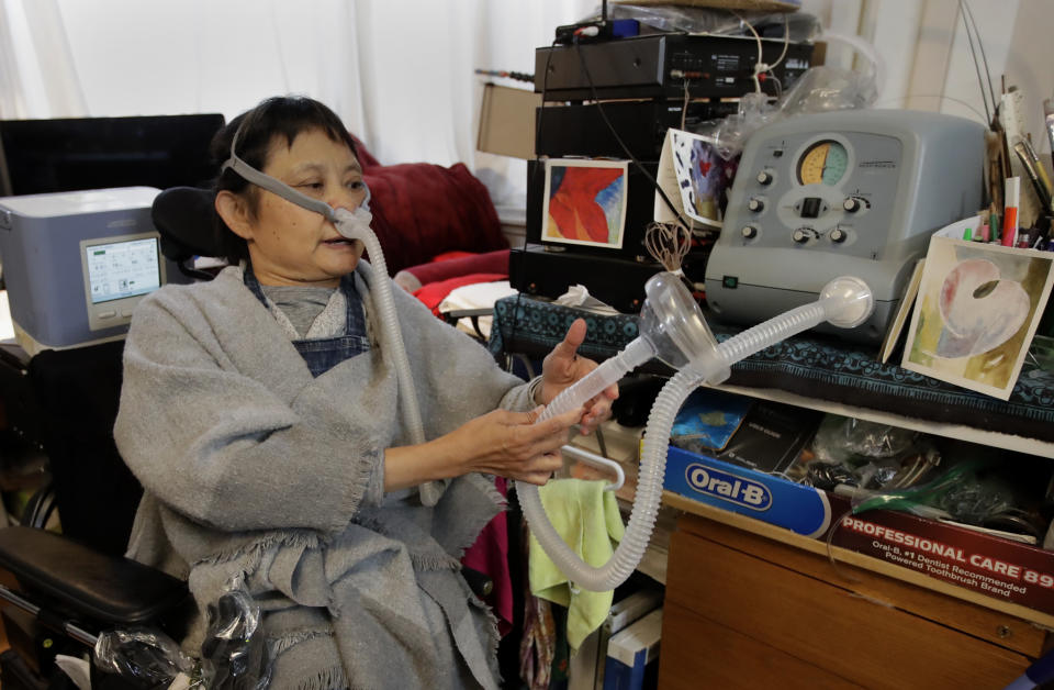 HOLD FOR STORY: In this photo taken on Monday, Dec. 2, 2019, Grace Lin gestures while speaking at her home in El Cerrito, Calif. An Associated Press review reveals persistent problems during four smaller shutoffs that Pacific Gas & Electric did starting last year so power lines downed by strong winds wouldn’t spark wildfires. “PG&E did nothing to help us who depend on electricity to run our life support,” recounted Lin, a polio survivor who needs a ventilator to breathe and uses an electric wheelchair. “It’s not like we could simply grind our teeth and tough it out by holding our breath.”(AP Photo/Ben Margot)