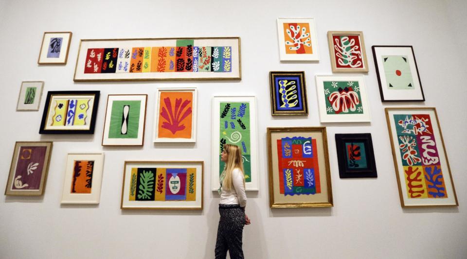 A woman looks at a wall of artworks by Henri Matisse, on display during a media opportunity at The Tate Modern in London, Monday, April 14, 2014. The artworks are part of the 'Henri Matisse: The Cut-Outs' exhibition that runs at the gallery from April 17 until Sept. 7, 2014.(AP Photo/Kirsty Wigglesworth)