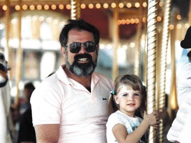 Meghan Thomas as a young child riding a carousel with her late father, Ken Thomas.