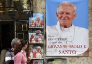 Pictures depicting the late Pope John Paul II are displayed in a shop in Rome April 23, 2014. REUTERS/Stefano Rellandini