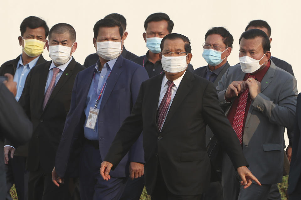 Cambodian Prime Minister Hun Sen, third right, arrives for a handing over ceremony at Phnom Penh International Airport, in Phnom Penh, Cambodia, Sunday, Feb. 7, 2021. Cambodia on Sunday received its first shipment of COVID-19 vaccine, a donation of 600,000 doses from China, the country's biggest ally. Beijing has been making such donations to several Southeast Asian and African nations in what has been dubbed "vaccine diplomacy," aimed especially at poorer countries like Cambodia. (AP Photo/Heng Sinith)