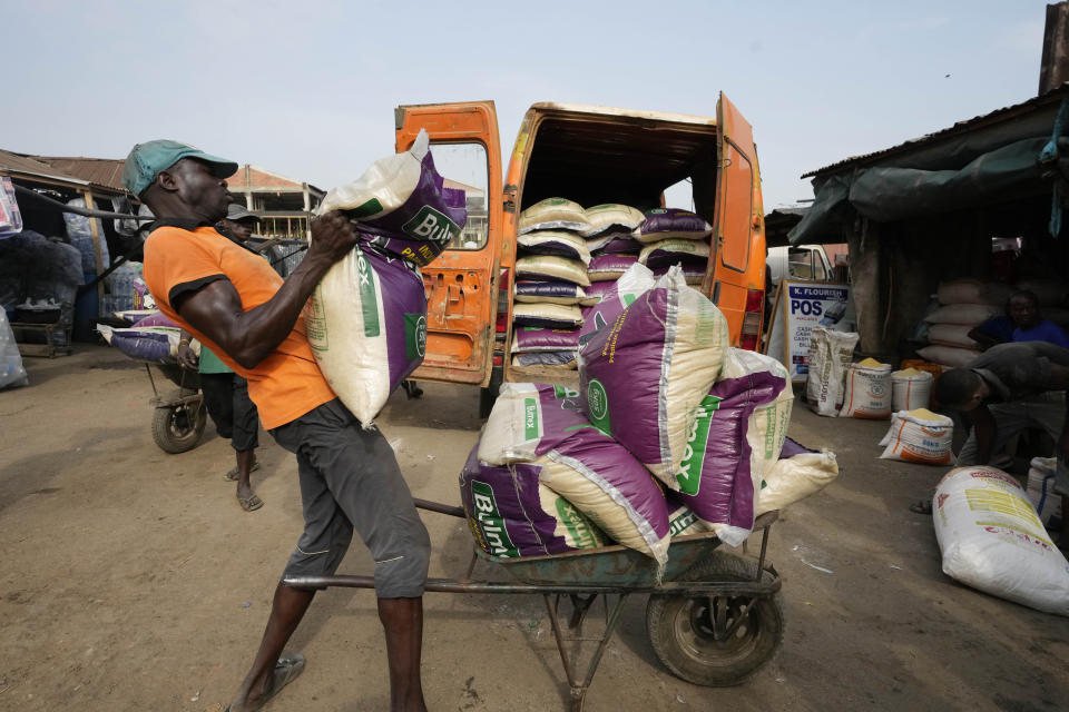 FILE- A workers loads bags of rice into a truck at a market in Lagos, Nigeria, Tuesday, Feb. 7, 2023. Nigeria's Bola Tinubu will take over the reins in Africa's most populous country at a period of unprecedented challenges, leaving some citizens hopeful for a better life and others sceptical that his government would perform better than the outgoing one on Monday May 29, 2023. (AP Photo/Sunday Alamba, File)