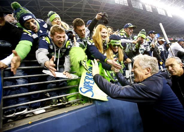 SEATTLE, WA - JANUARY 19:  Head coach Pete Carroll of the Seattle Seahawks celebrates with fans after the Seahawks 23-17 victory against the San Francisco 49ers during the 2014 NFC Championship at CenturyLink Field on January 19, 2014 in Seattle, Washington.  (Photo by Jonathan Ferrey/Getty Images)