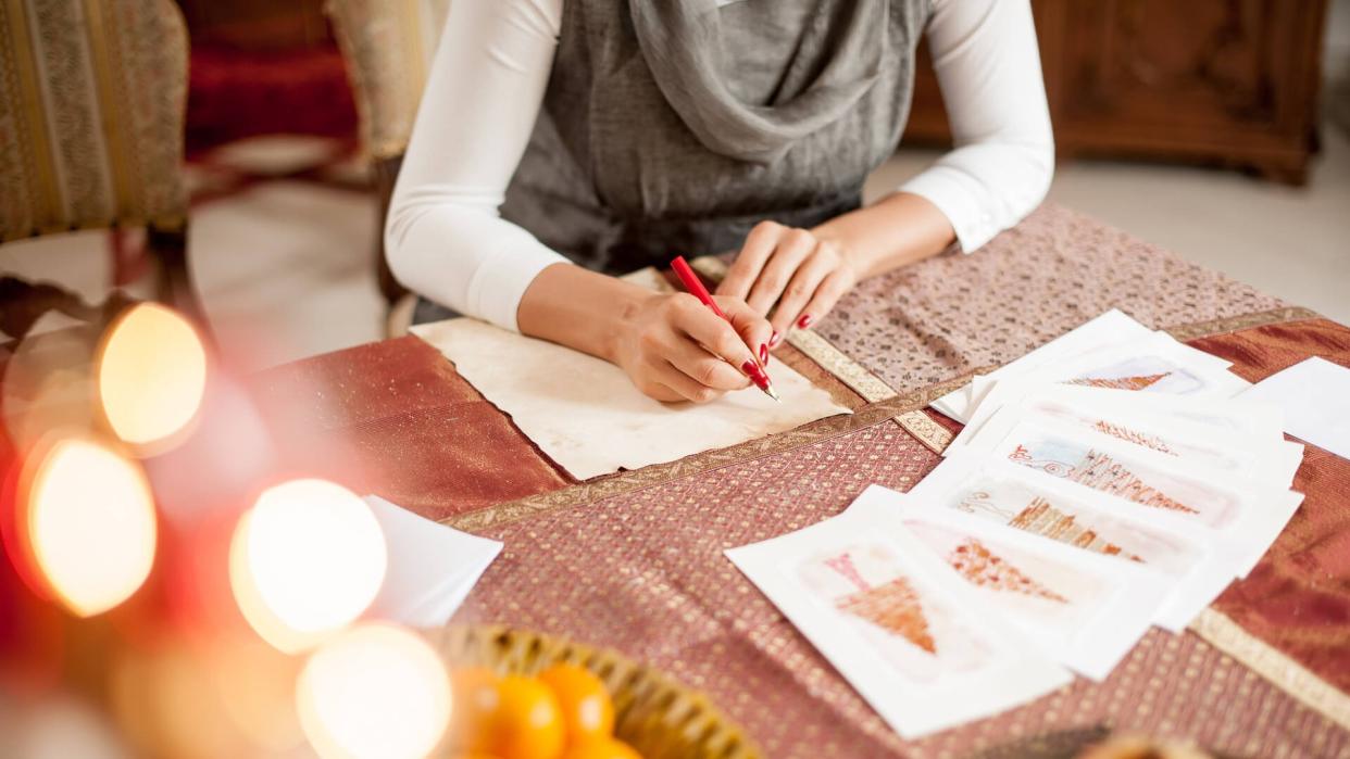 Woman Writing a Christmas Card on Table.