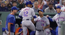 New York Mets' Francisco Lindor (12) is congratulated after scoring on a bases-loaded walk by Boston Red Sox starting pitcher Eduardo Rodriguez during the fourth inning of a baseball game at Fenway Park, Tuesday, Sept. 21, 2021, in Boston. (AP Photo/Charles Krupa)