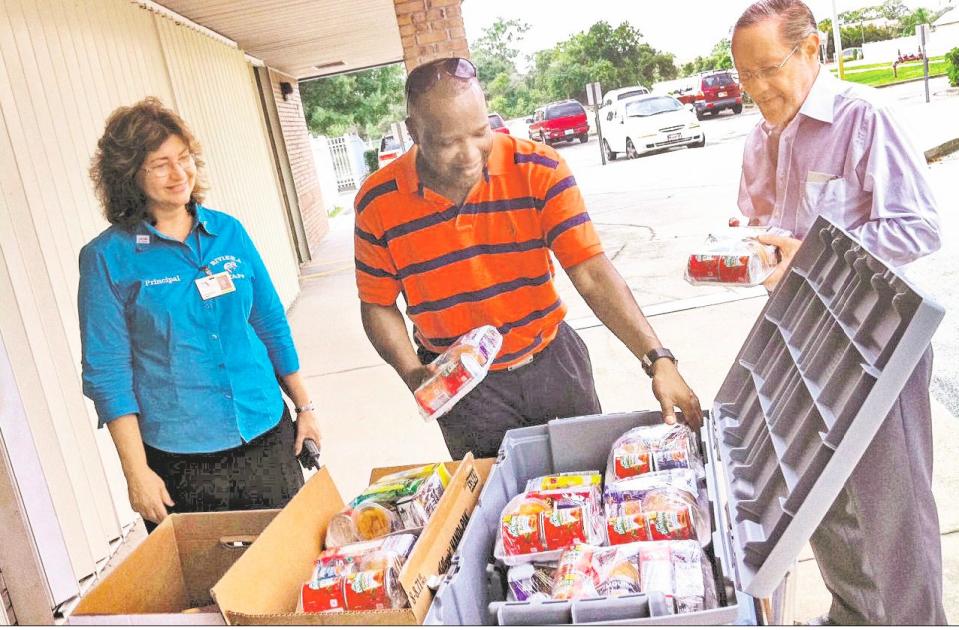 In a photo from August 2011, Children's Hunger Project founder Bob Barnes, right, is pictured at the nonprofit's first delivery of weekend food supplies with then-principal Linda Piccolella of Riviera Elementary School and Sam Jordan, center.