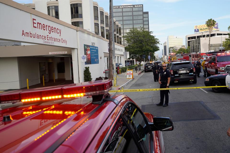 Police and emergency personnel stand outside Encino Hospital Medical Center on Friday, June 3, 2022, in Los Angeles. A man stabbed a doctor and two nurses inside the hospital's emergency ward Friday and remained inside a room for hours before police arrested him, authorities said.