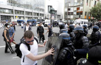 A protestor pushes on the shield of a police officer during a demonstration in Paris, France, Saturday, July 31, 2021. Demonstrators gathered in several cities in France on Saturday to protest against the COVID-19 pass, which grants vaccinated individuals greater ease of access to venues. (AP Photo/Adrienne Surprenant)