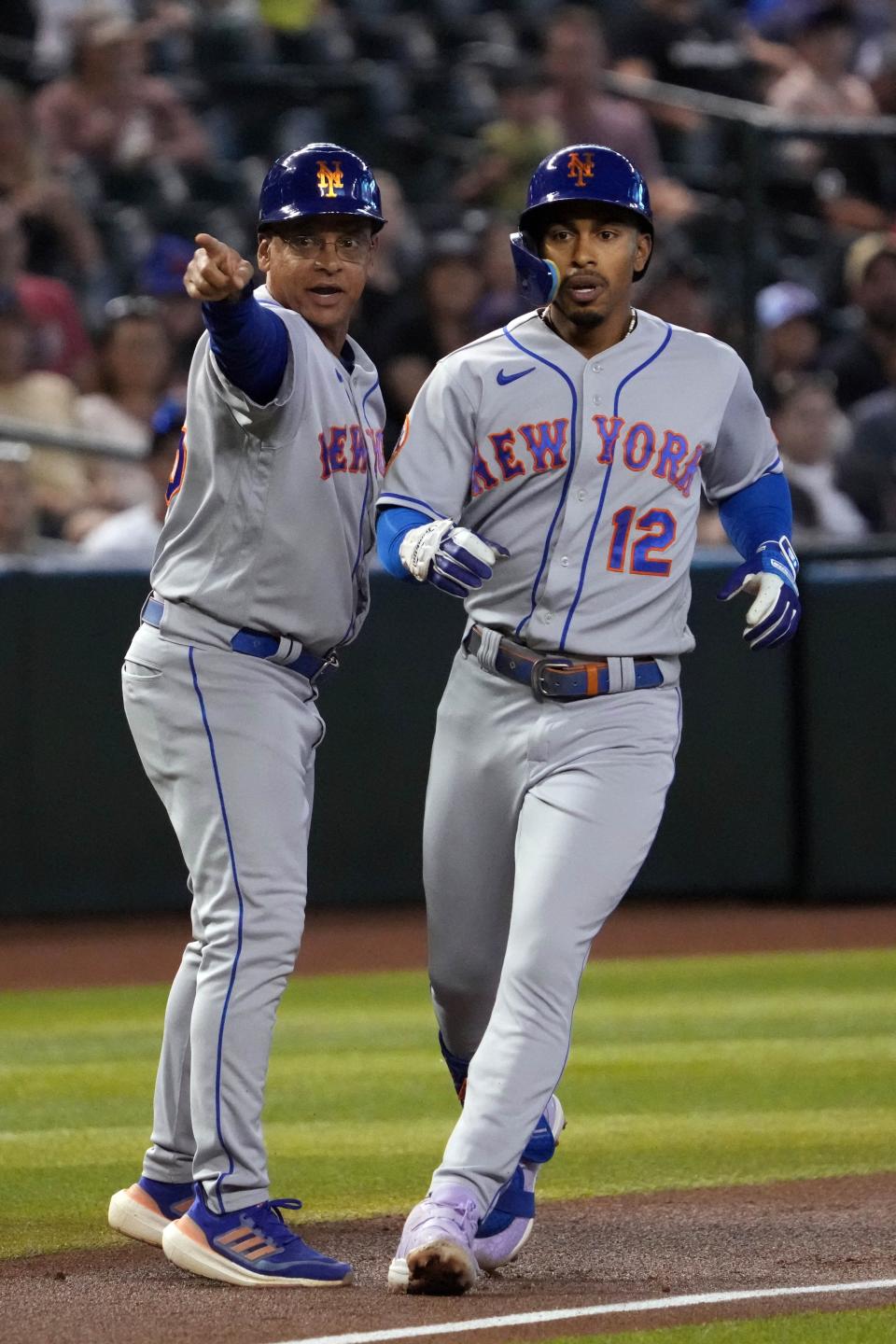 New York Mets shortstop Francisco Lindor (12) gets instructions from New York Mets infield & third base coach Joey Cora (56) after hitting a triple against the Arizona Diamondbacks during the first inning at Chase Field in Phoenix on July 6, 2023.