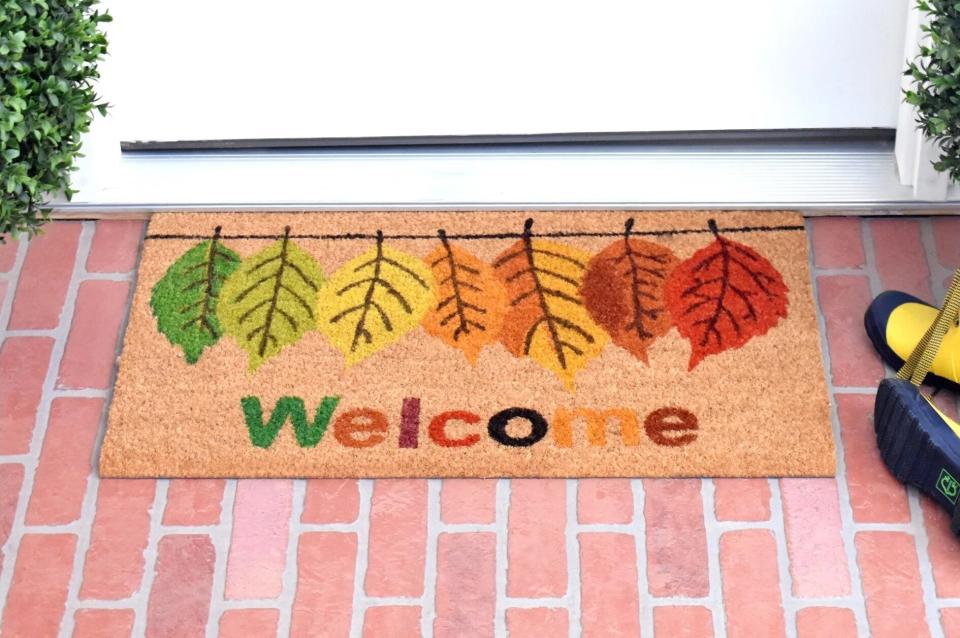 The doormat, which reads "welcome" and has leaves in various colors