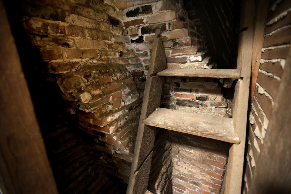 In this Thursday, Dec. 13, 2018 photo a set of steps rests against a twisting portion of a chimney at the home in Framingham, Mass., where Sarah Clayes lived after leaving Salem, Mass., following the 1692 witch trials. The once-run-down home that stands where Clayes, a woman accused of witchcraft during the 1692 Salem witch trials settled, is on the market after an extensive renovation project. (AP Photo/Steven Senne)