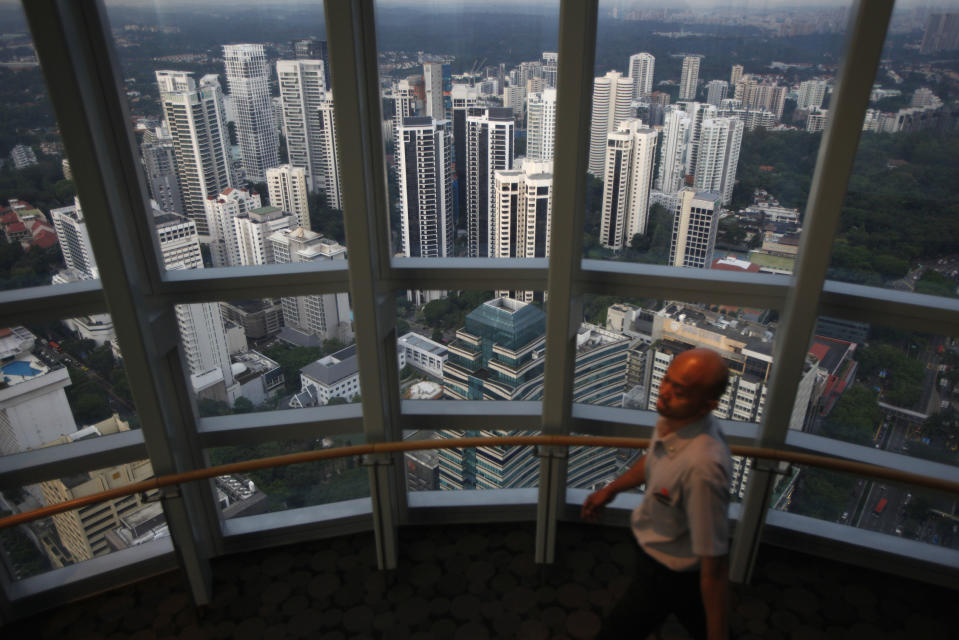 A man walks on an observation deck overlooking private high-rise residential condominium properties in the prime Orchard Road district in Singapore April 15, 2014. Luxury property developers in Singapore are facing their worst sales outlook in six years as a raft of government measures to cool one of the world's most expensive real estate markets bite. Sales of private homes, which account for just under one-fifth of the total property market, fell to their lowest in more than four years in January to March, official data showed this week.  To match story SINGAPORE-PROPERTY/      Picture taken April 15, 2014.  REUTERS/Edgar Su (SINGAPORE - Tags: BUSINESS REAL ESTATE)