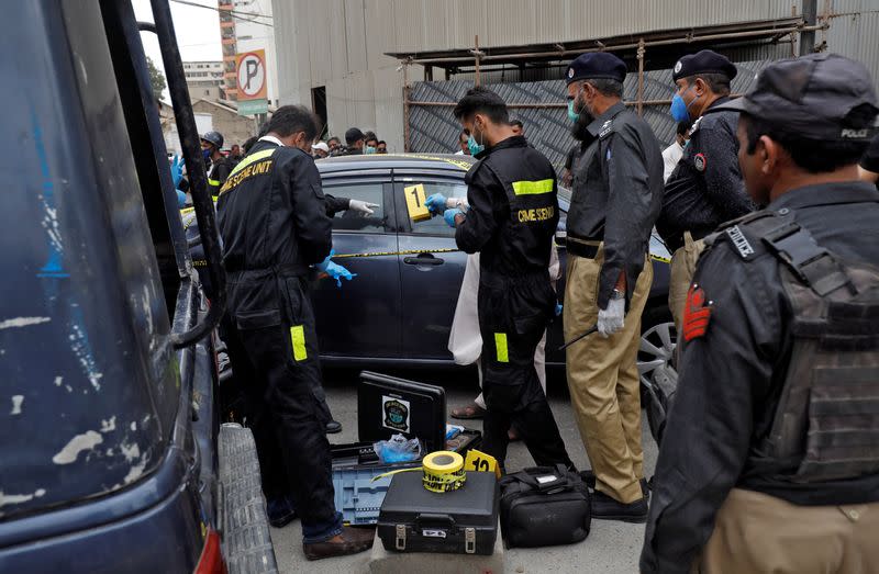 Members of Crime Scene Unit of Karachi Police examine the site of an attack at the Pakistan Stock Exchange in Karachi