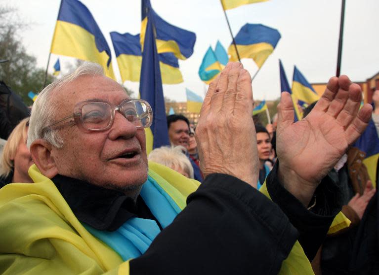 A pro-Ukrainian supporter applauds during a mass rally in the eastern Ukrainian city of Donetsk, on April 17, 2014