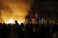 Protesters gather in front of the burning Minneapolis police 3rd Precinct building Thursday, May 28, 2020, in Minneapolis. Protests over the death of George Floyd, a black man who died in police custody Monday, broke out in Minneapolis for a third straight night. (AP Photo/Julio Cortez)