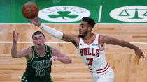 Chicago Bulls forward Troy Brown Jr., left, grabs a rebound over Boston Celtics guard Payton Pritchard, right, during the first half of an NBA basketball game, Monday, April 19, 2021, in Boston. (AP Photo/Charles Krupa)