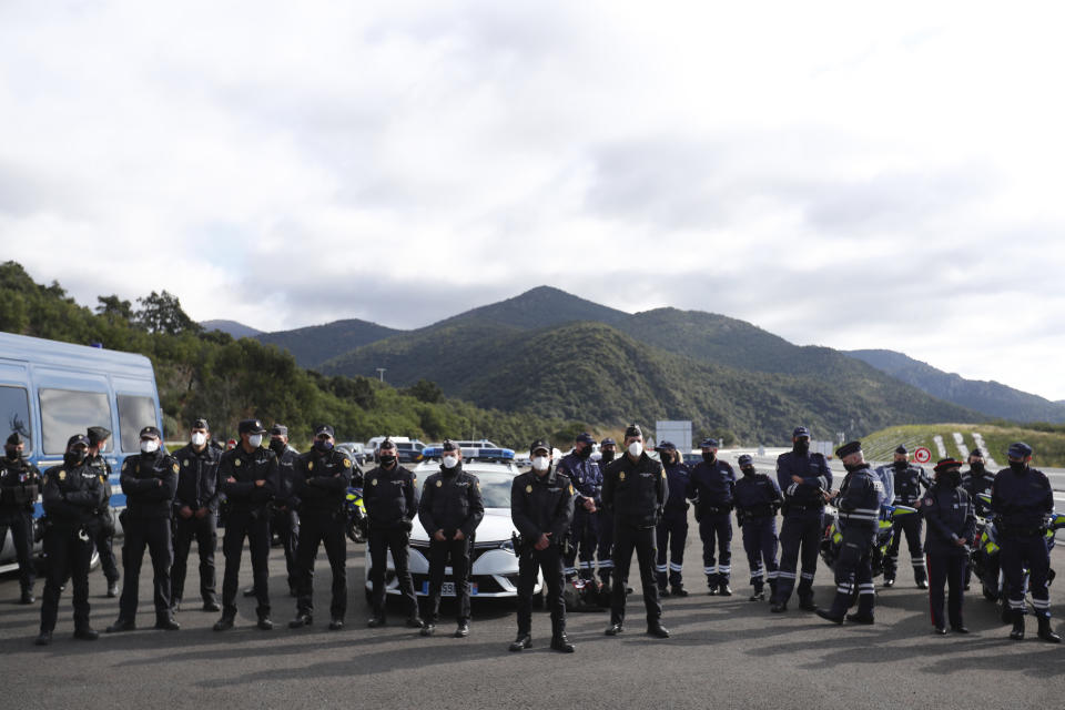 French police officers stand in line as French President Emmanuel Macron holds a visit on the strengthening border controls at the crossing between Spain and France, at Le Perthus, France, Thursday, Nov. 5, 2020. (Guillaume Horcajuelo, Pool via AP)