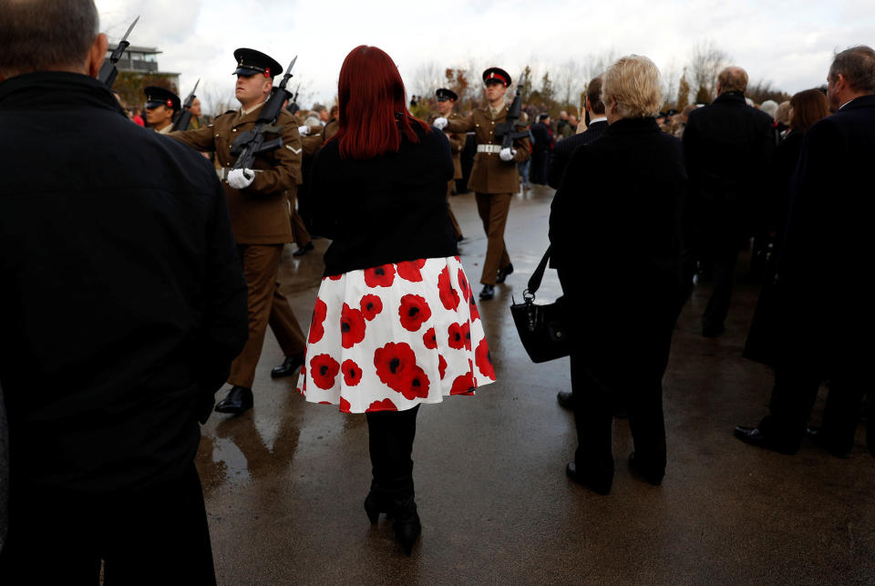 <p>A woman wearing a poppy print dress watches a parade during Armistice Day commemorations at the National Memorial Arboretum in Alrewas, Britain, Nov. 11, 2017. (Photo: Darren Staples/Reuters) </p>