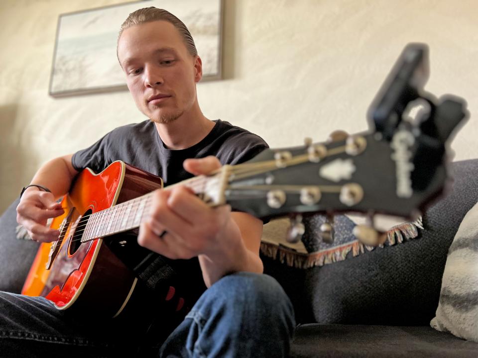 Mason Shane plays his acoustic guitar. He began playing guitar when he was 7 years old and his father bought him a miniature Fender Stratocaster. "Within four years, I was in a kids' rock band called Encore," he said.