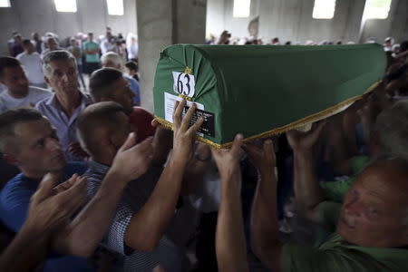 Bosnian Muslims carry a coffin of their relative among the 136 newly identified victims of the 1995 Srebrenica massacre lined up for a joint burial in Potocari, Bosnia, July 9, 2015. REUTERS/Dado Ruvic