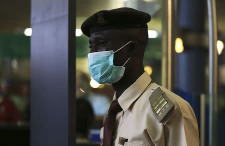 An immigration officer wears a face mask at the Nnamdi Azikiwe International Airport in Abuja August 11, 2014. REUTERS/Afolabi Sotunde