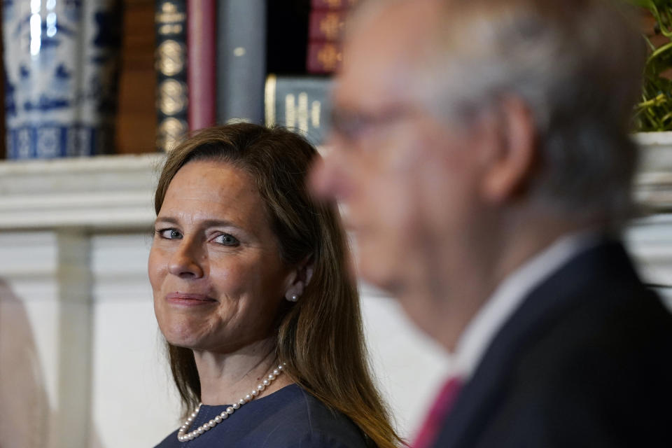 Supreme Court nominee Judge Amy Coney Barrett looks over to Senate Majority Leader Mitch McConnell of Ky., as they meet with on Capitol Hill in Washington, Tuesday, Sept. 29, 2020. (AP Photo/Susan Walsh, POOL)