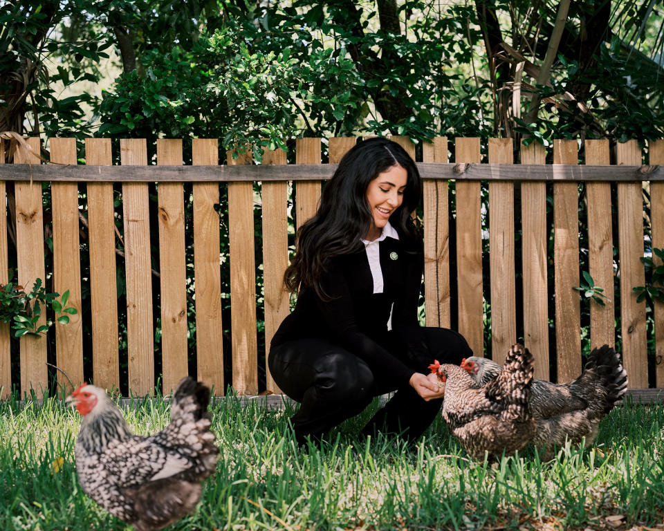 Luna feeds her chickens at home after returning from the office on July 6.<span class="copyright">Zack Wittman for TIME</span>