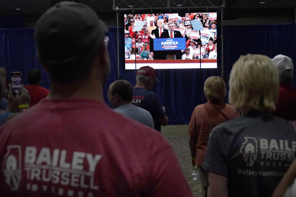 Supporters of Republican gubernatorial primary candidate Illinois state Sen. Darren Bailey watch a video Tuesday, June 28, 2022, in Effingham, Ill., at Bailey election headquarters, of former President Trump recently campaigning for Bailey. (AP Photo/Charles Rex Arbogast)