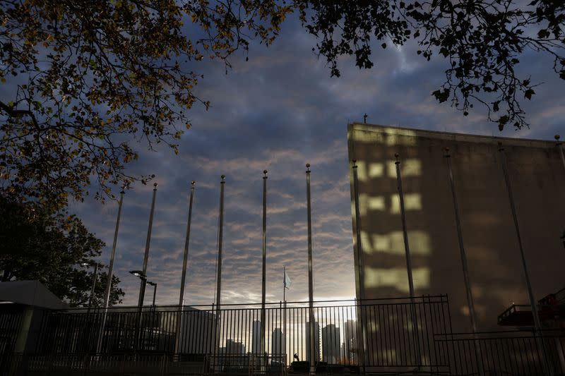 The flag representing the United Nations blows in the wind at UN headquarters during sunrise in New York City