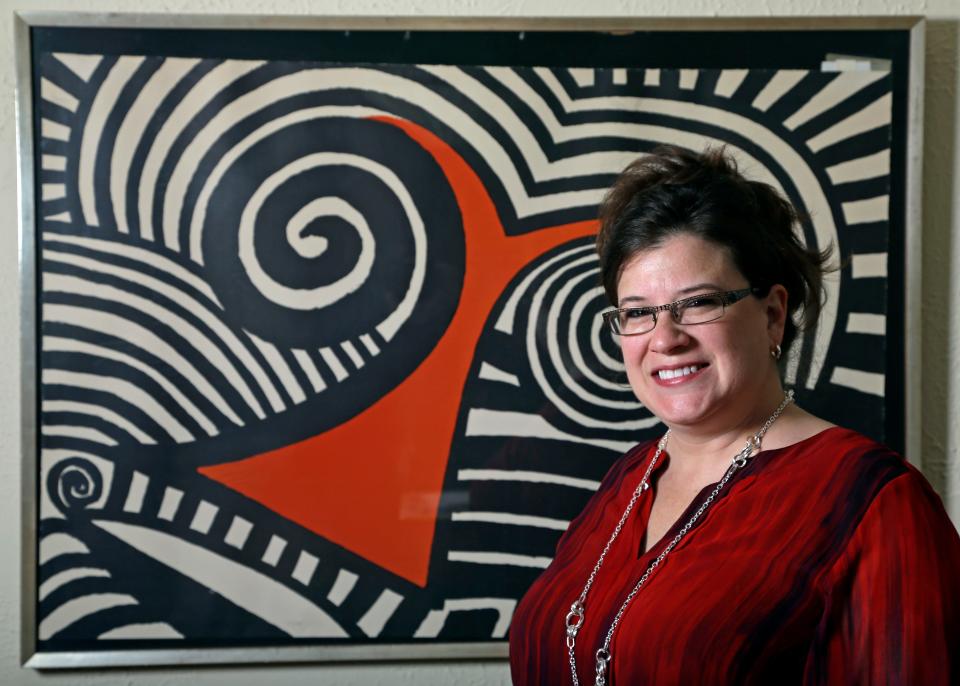 In this Wednesday, Nov. 28, 2012 photo, Karen Mallet stands in front of her Alexander Calder print in her Shorewood, Wis., home. Mallet bought the print for $12.34 at a Goodwill thrift store in Milwaukee. It turned out to be a lithograph by the American artist Alexander Calder worth $9,000. (AP Photo/Morry Gash) ORG XMIT: WIMG902