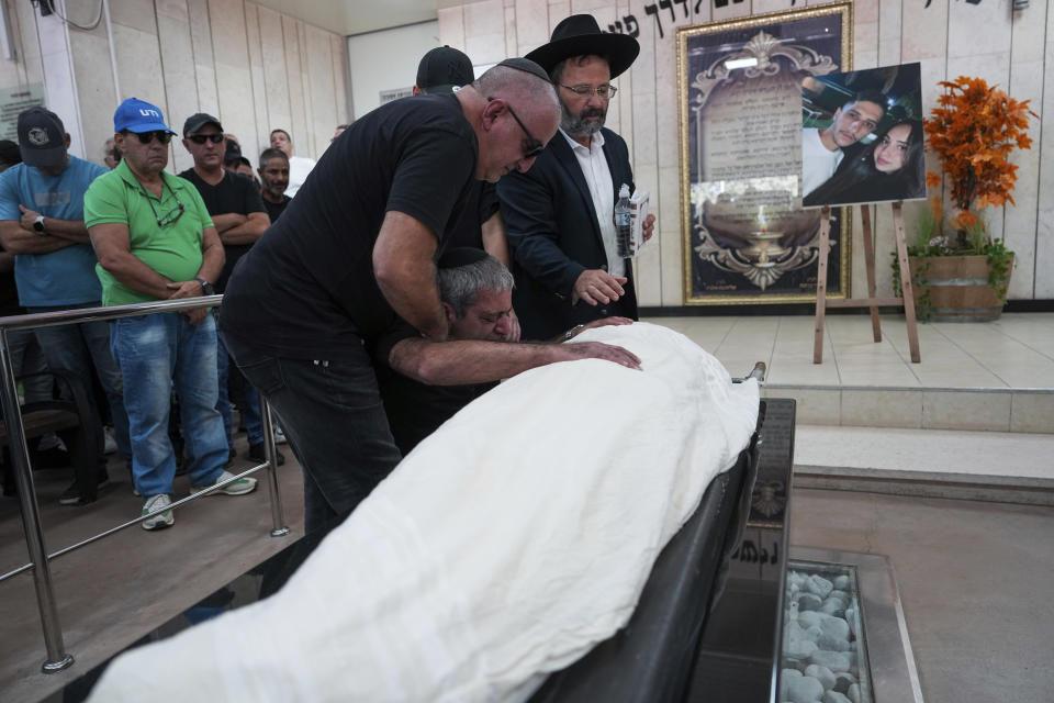 Father of Naor Hassidim grieves over his son's body, during his funeral in Ashdod, Israel, Monday, Oct. 16, 2023. Hassidim and his partner were killed by Hamas militants on Oct. 7 in Kibbutz Kfar Azza, close to the Gaza Strip's separation fence with Israel, as the militant Hamas rulers of the territory carried out an unprecedented, multi-front attack that killed over 1,300 and captured many Israelis. (AP Photo/Tsafrir Abayov)