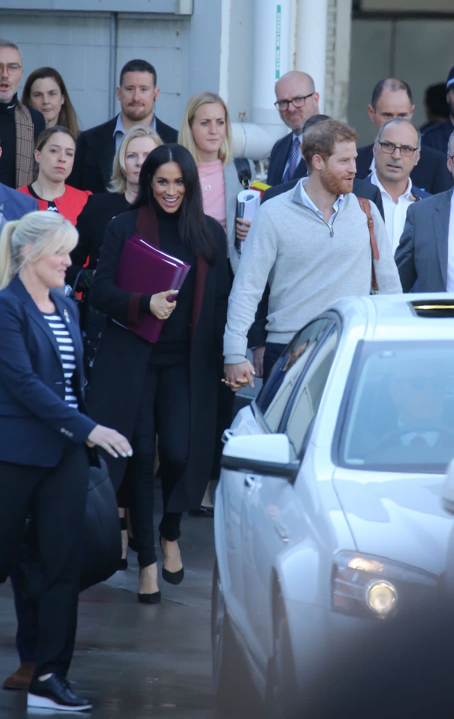 <p>Prince Harry and Meghan Markle touched down in Sydney for <a href="https://www.townandcountrymag.com/society/tradition/a21273366/meghan-markle-prince-harry-first-royal-tour-2018/" rel="nofollow noopener" target="_blank" data-ylk="slk:their royal tour;elm:context_link;itc:0;sec:content-canvas" class="link ">their royal tour </a>with some news to share: <a href="https://www.townandcountrymag.com/society/tradition/a23773992/meghan-markle-pregnant-first-royal-baby-prince-harry/" rel="nofollow noopener" target="_blank" data-ylk="slk:the Duchess is pregnant!;elm:context_link;itc:0;sec:content-canvas" class="link ">the Duchess is pregnant!</a> Meghan wore a black coat with a maroon trim for the occasion, with a black turtleneck and matching pants. </p>
