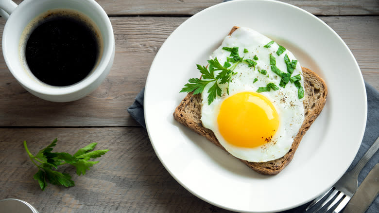 Fried egg on toast with cup of coffee