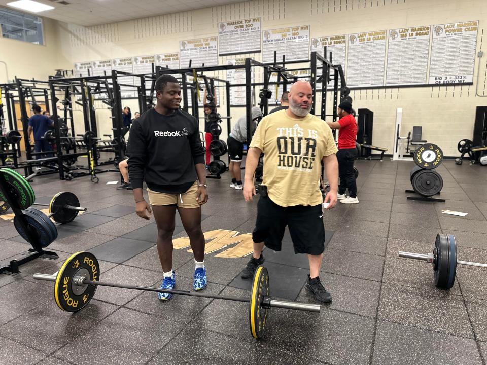 Strength-and-conditioning coach Jerry Clark stands with a student athlete after he does a set at Warren Central High School in Indianapolis. Clark’s two goals with strength and conditioning is injury prevention and an improvement with physical capabilities.