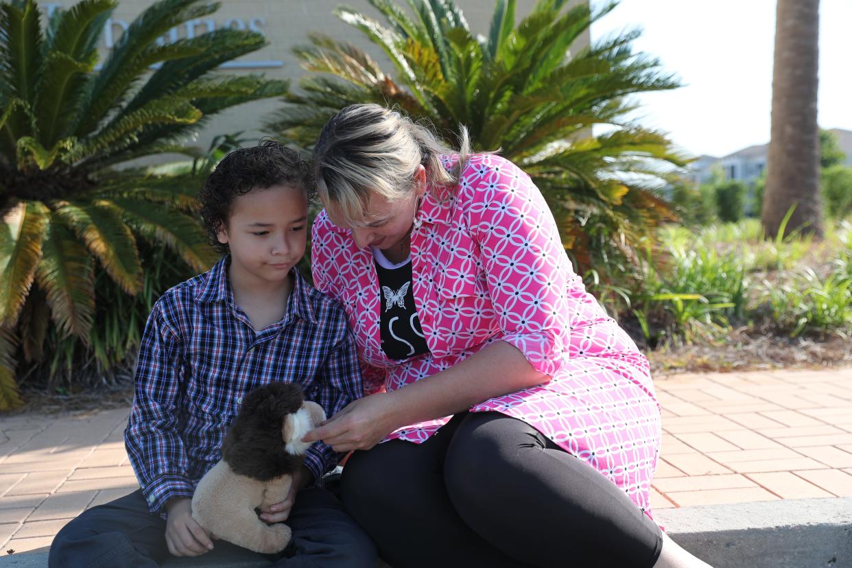 Laura Alvarez talks with her son about his stuffed lion outside of a public library on Tuesday, May 16, 2023.