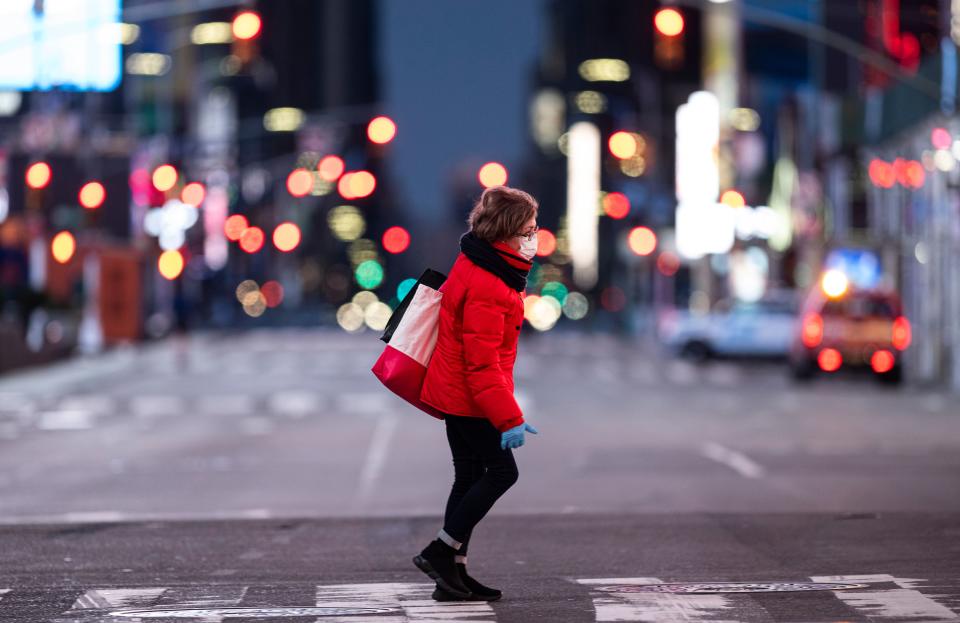 A woman walks through an almost-deserted Times Square in the early morning hours on April 23, 2020 in New York City. - Job losses from the coronavirus pandemic deepened last week with data Thursday showing another 4.4 million US workers filed new claims for jobless benefits, bringing the total to 26.4 million since mid-March. (Photo by Johannes EISELE / AFP) (Photo by JOHANNES EISELE/AFP via Getty Images)