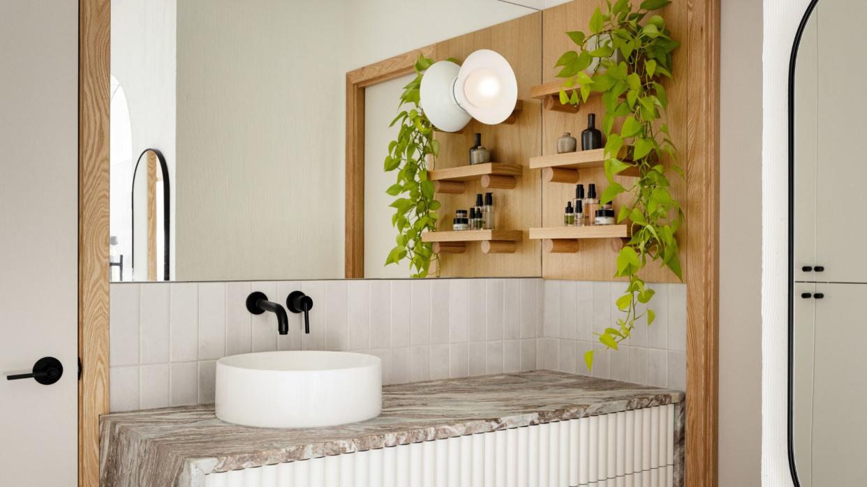  Bathroom vanity with full wall length mirror, round sink with black taps, white fluted vanity with grey marble worktop, wood shelves with plants on wall. 