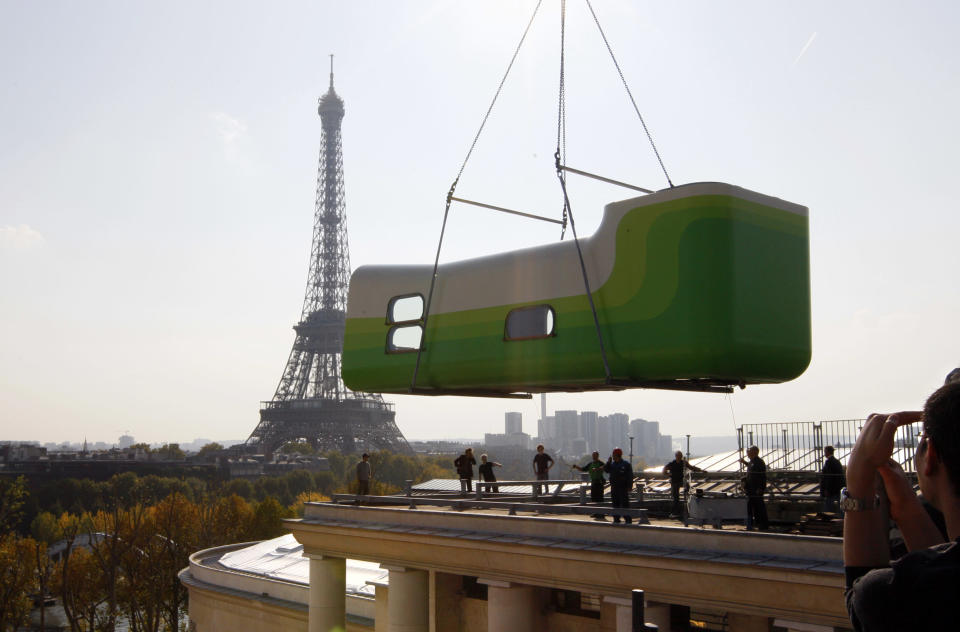 "Hotel Everland" (R), a creation by Swiss artists Sabina Lang and Daniel Baumann, is craned on the roof of Paris Modern Art Museum, the "Palais de Tokyo, site de creation contemporaine", October 16, 2007. The "Hotel Everland" is an art installation consisting of an actual one-room hotel offering 1970s-style glamour, artistic cachet, a view of the Eiffel Tower, functioning as both a museum exhibit and a room where people can stay overnight. REUTERS/Philippe Wojazer