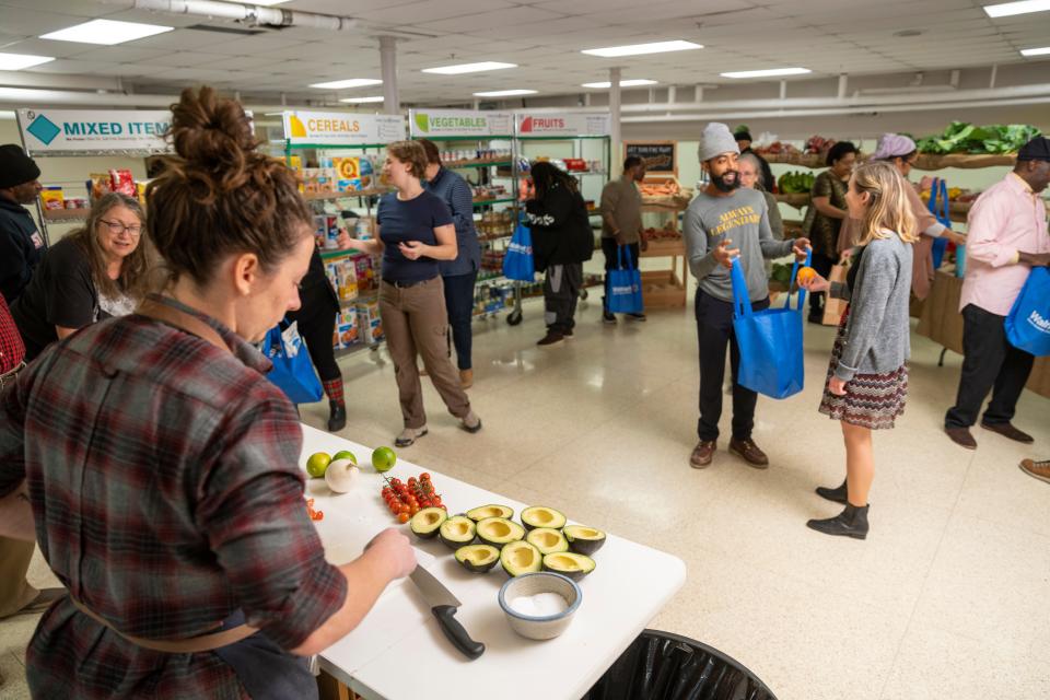 Food center director Caitlin Cullen, left, prepares guacamole during a food demonstration at Kinship Community Food Center in Milwaukee's Riverwest neighborhood.