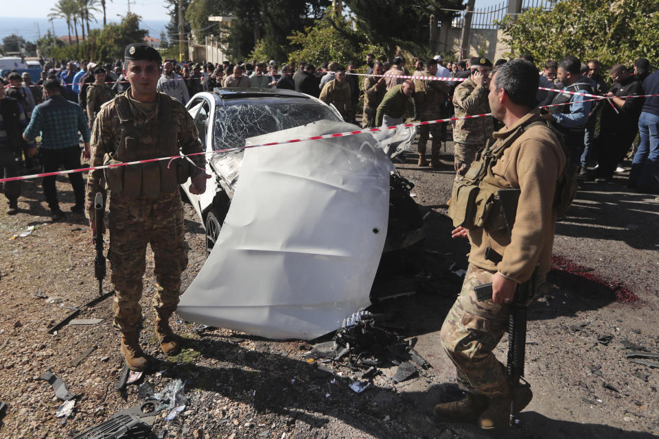 Lebanese army soldiers stand next of a destroyed car near the coastal town of Jadra, south Lebanon, Saturday, Feb. 10, 2024. An apparent Israeli drone strike hit a car near Lebanon's southern port city of Sidon Saturday killing at least two people and wounded others, security officials said. (AP Photo/Mohammed Zaatari)